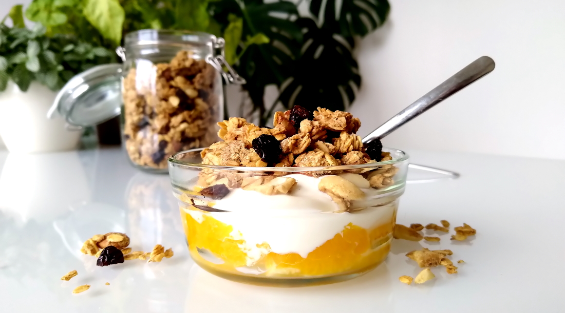 Cashew-sinaasappelgranola met cranberry’s, yoghurt en verse sinaasappel