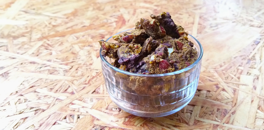 Keto pompoengranola in glazen schaaltje op houten blad